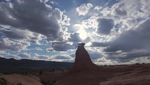 Walking towards hoodoo in the Escalante desert silhouetted by the sun.