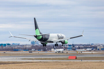 Naklejka premium Mississauga Canada, April 9, 2022; An Ultra low-cost carrier Flair Airlines Boeing 737 Max 8 jet clearing the fence at the end of the runway for landing at at Toronto Pearson Airport YYZ