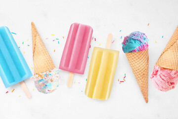 Assortment of colorful summer popsicles and ice cream desserts. Above view flat lay on a bright...