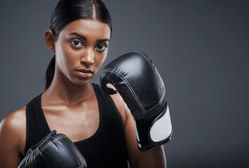 Portrait, boxing gloves and Indian woman in studio for sports, combat and training for fitness....