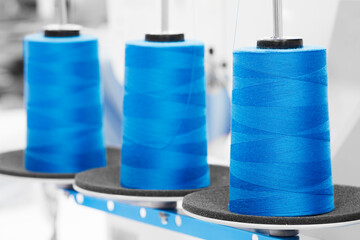 Spools of blue color threads closeup, spinning machine