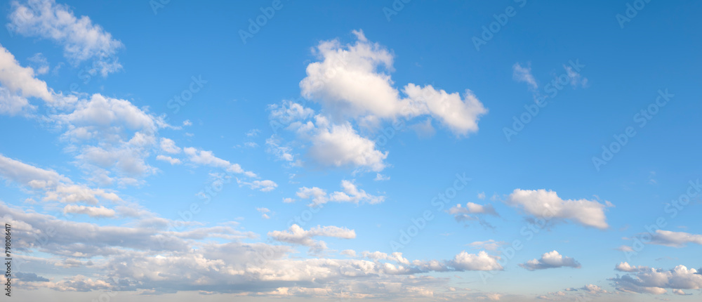 Poster the sky is blue with a few clouds scattered throughout. the clouds are white and fluffy, giving the 