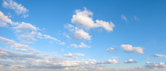 The sky is blue with a few clouds scattered throughout. The clouds are white and fluffy, giving the...
