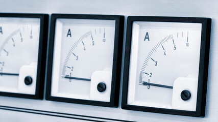 Three black and white electrical meters with white numbers on them. The numbers are in the range of...