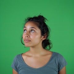 Fototapeta premium Hopeful Reflections: Young Latin Woman Looking Up with Quiet Anticipation