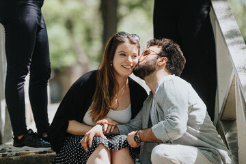 A young couple shares a carefree moment in a city park on a sunny day, exemplifying a relaxed,...