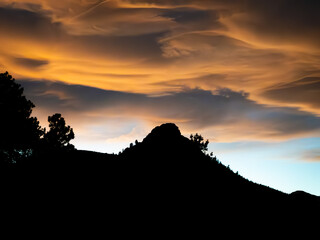 Sunset and dramatic clouds over a mountain peak