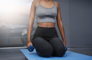 Fototapeta premium Fitness, girl and dumbbells in home for exercise, yoga and workout on mat in apartment. Female athlete, pilates and training for health, wellness and muscle strength or arms with endurance in sports