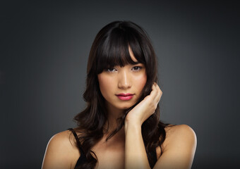 Fototapeta premium Portrait, asian woman and hair care in studio background for curls with keratin, beauty and mockup space. Female person, face and texture for salon, shampoo or cosmetics with pride or confidence