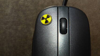 Souris d'ordinateur avec le symbole de la radioactivité indiqué sur le clic gauche