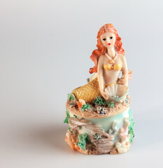 Mermaid figurine on a white background. Fairytale character. Toy mermaid. Feminine appearance