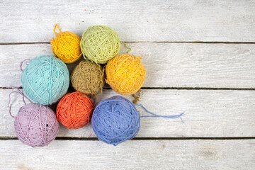 Colored yarn on a white wooden table. Skeins of wool yarn for knitting. Balls of wool of different colours for handmade knitting on a wooden background with copy space for ad. - 798134450