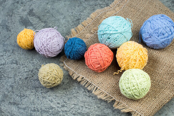 Colored yarn on a gray concrete background. Skeins of wool yarn for knitting. Balls of wool of different colours for handmade knitting on a wooden background with copy space for ad. - 798134471
