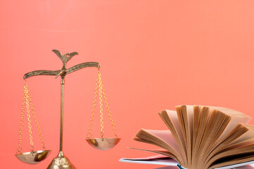Law concept - Open law book, Judge's gavel, scales, Themis statue on table in a courtroom or law enforcement office. Wooden table, orange background. - 798134677