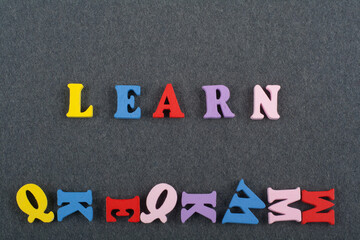 LEARN word on black board background composed from colorful abc alphabet block wooden letters, copy space for ad text. Learning english concept. - 798134813