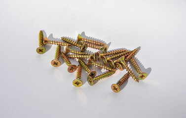 group of screws. yellow screws for wood on a white background. screws for fastening