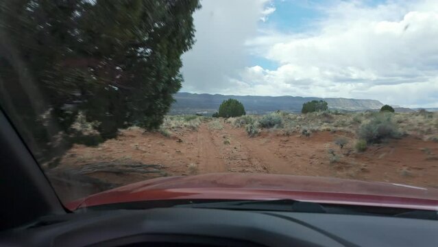 POV driving on dirt road in the Escalante desert bouncing over the rolling hills.