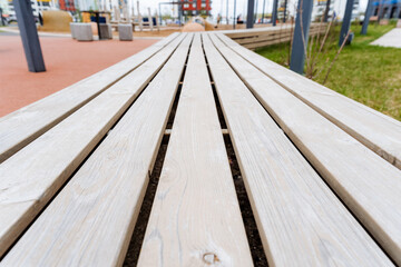 Closeup of hardwood bench with parallel wooden planks in park