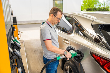 The driver fills up expensive gasoline in self-service filling station in Europe