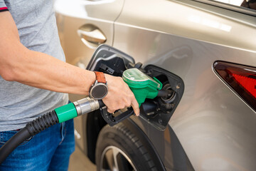 Close up view of driver hand fills up expensive gasoline in self-service filling station in Europe