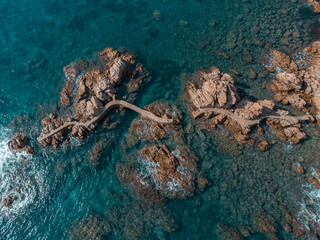 Aerial view of the broken walkway of the reefs of Rosamar. Crystal clear water at Camí de Ronda,...
