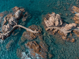 Aerial view of the broken walkway of the reefs of Rosamar. Crystal clear water at Camí de Ronda,...
