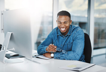 Portrait, happiness and black man in modern office with laptop, paperwork and laugh at desk....