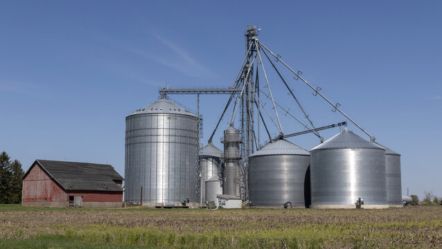 Brock Corn or Grain bins on a farm. Elevators and grain legs direct corn supply to bins. Brock is part of Berkshire Hathaway.