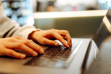 Close - up of woman's hands typing on laptop keyboard at home. Cyber security concept. Freelancer,...