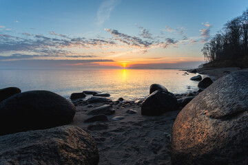 rocky shore of the Baltic sea at dawn, stones in the foreground