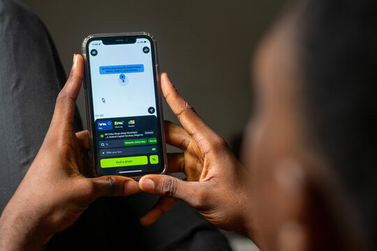 african man using Indrive apps on on Apple smartphone, guy trying to book a drive from his comfort zone. Indrive is sharing-economy service for urban transport. Abuja, F.C.T, Nigeria - 26 April 2024
