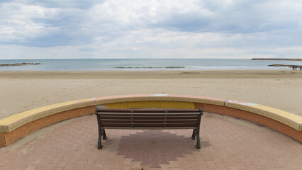 banc vide devant une plage vide au bord de mer