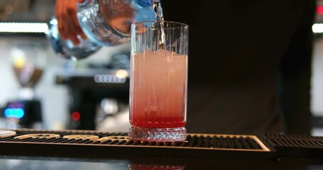  Bartender makes a cocktail drink water Soda is poured into a glass Close-up