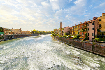 The bell tower of the 13th century Basilica di Santa Anastasia can be seen at late afternoon from the Ponte Pietra bridge in the medieval old town of Verona, Italy.