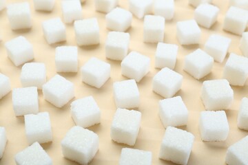 White sugar cubes on beige background, closeup