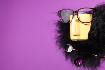 Man's face made of artificial beard, cup and glasses on purple background, top view. Space for text