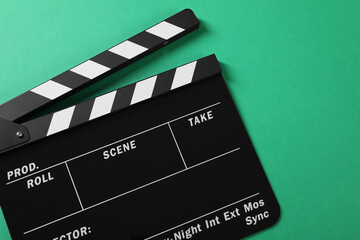 Obraz premium Clapperboard on green background, top view. Space for text
