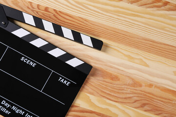 Clapperboard on wooden table, top view. Space for text