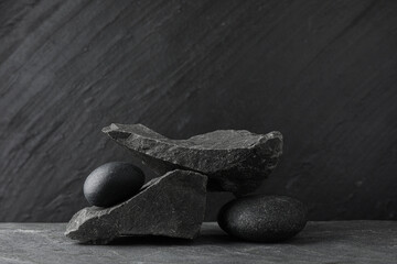 Presentation for product. Podium made of different stones on grey textured background. Space for...