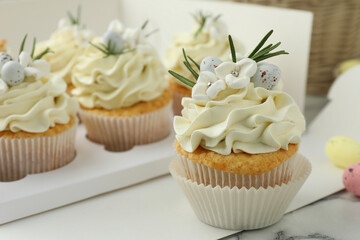 Tasty Easter cupcakes with vanilla cream on table, closeup