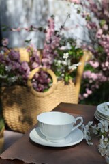 Beautiful spring flowers on table served for tea drinking in garden, closeup