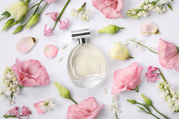 Luxury perfume and floral decor on white background, flat lay