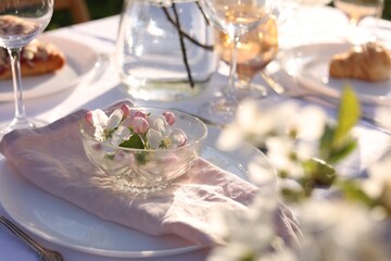 Stylish table setting with beautiful spring flowers in garden
