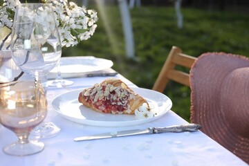 Stylish table setting with beautiful spring flowers in garden