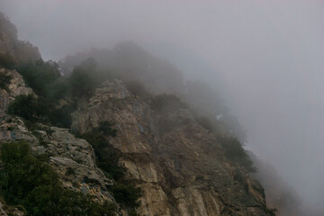 View of the rocky landscape covered in misty clouds at the Amalfi Coast, Province of Salerno, Campania, Italy
