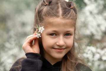 portrait of a little girl in a blooming garden