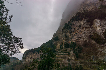 View of the rocky landscape covered in misty clouds at the Amalfi Coast, Province of Salerno, Campania, Italy