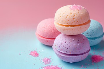 Three bath bombs sitting on top of each other on a blue surface with pink and blue sprinkles