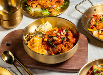 Korean Spicy Chicken Bento with spoon and chopsticks served in golden dish isolated on wooden board side view of honk kong food