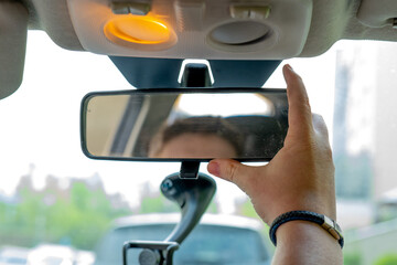Interior mirror of a passenger car. Adjusting the mirror in the car. Driving test.